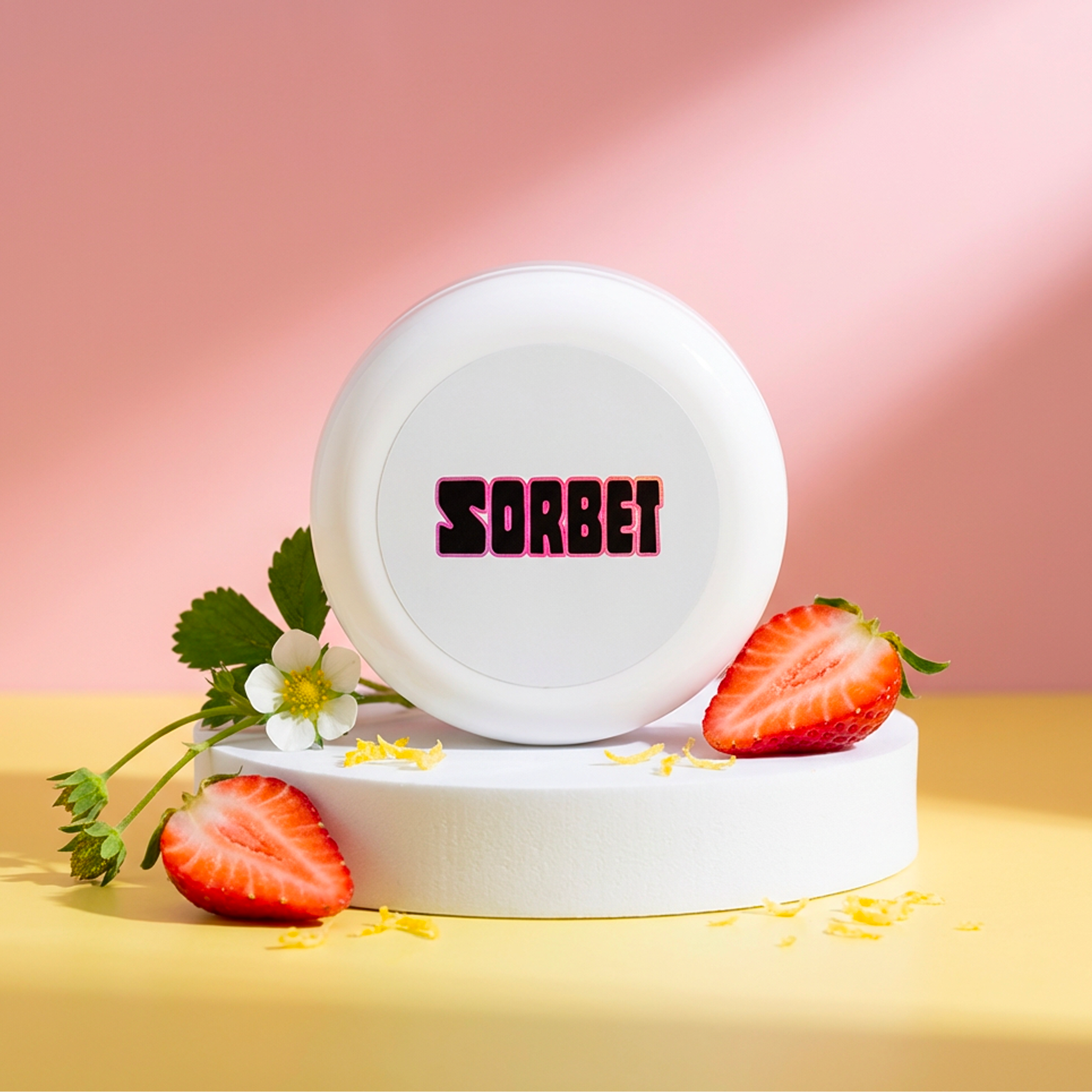 White container with 'SORBET' text, surrounded by strawberries and flowers on a pink background